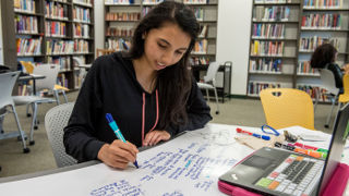 Student taking notes in the library