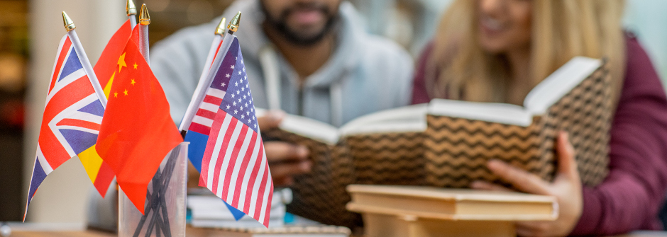 International flags in a cup and students reading books in the background.
