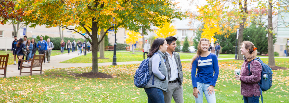 A group of four students talking on campus. 