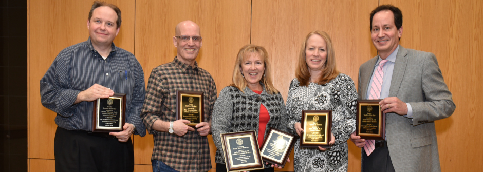 A photo of a group of faculty holding award plaques.