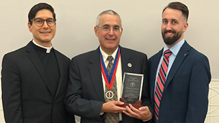 Image of Dr. Travaline receiving the award