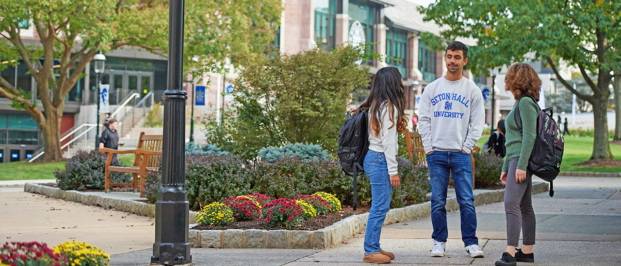 Students talking and walking on campus. 