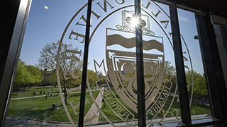 A photo of the window in the University Center that has the University seal etched on it.