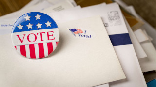 Vote button laying on enveloped next to an