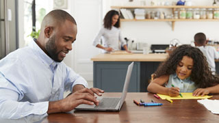 A family working from home on their computers.