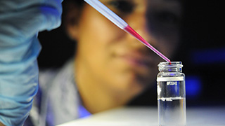 Scientist pipetting a vial