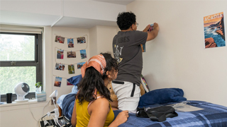 Image of two students decorating a dorm room 