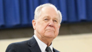 Photo of Jim McGlone, a pale man who is about 70 years old, has white hair, and is wearing a navy suit.