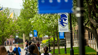 Students walking campus with a Pirate's Banner hanging