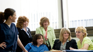 Image of nurses and health care administrators in a room smiling.