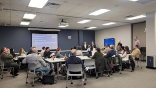 TLTR Committee members gather in Walsh Library Beck Rooms A for a presentation.