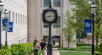 Image of two students walking across campus. 