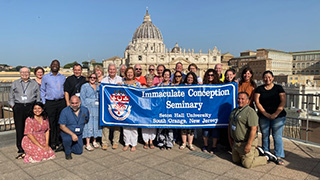 a group from Seton Hall in Rome holding a sign that says "Immaculate Conception Seminary"