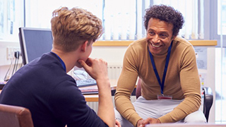 Student with advisor A student talking one on one with an advisor wearing a lanyard.