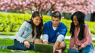 Students sitting at a laptop in the spring Students sitting at a laptop in the spring